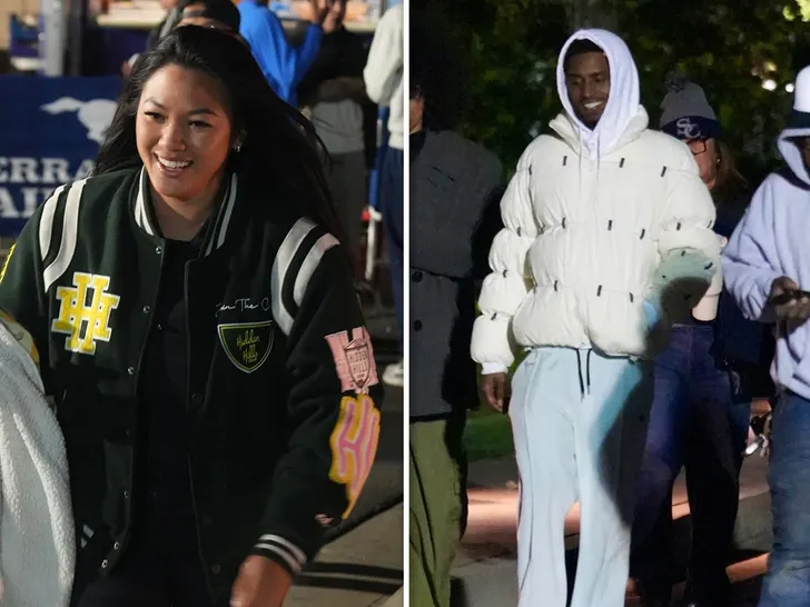 Diddy and daughter Jessie share a joyful moment, smiling at each other on the sidelines.